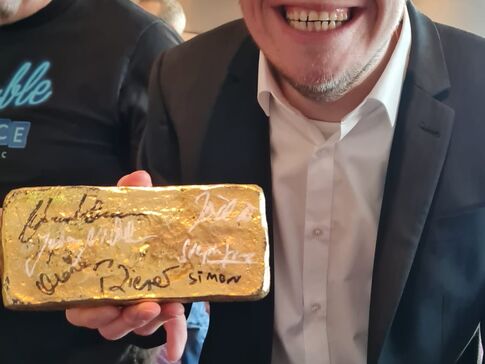 Simon Rupp mit einem Goldbarren voller Autogramme